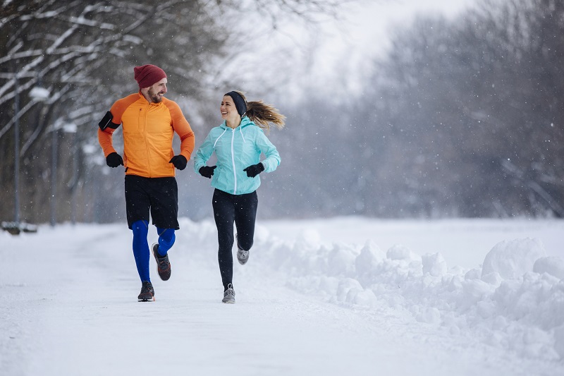 a woman and a man exercising in snowy conditions