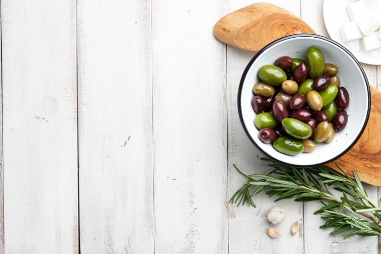 a small bowl of different colored olives with thyme as garnish - South ...