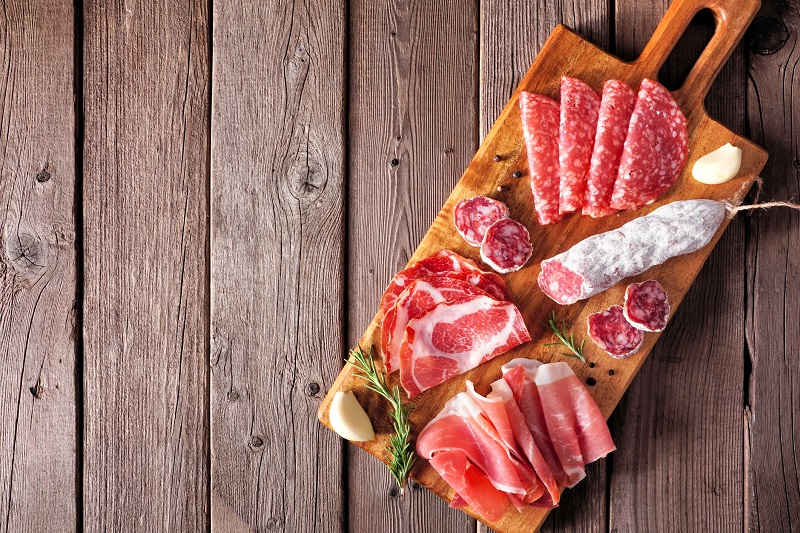 a variety of cured meats on a charcuterie board 
