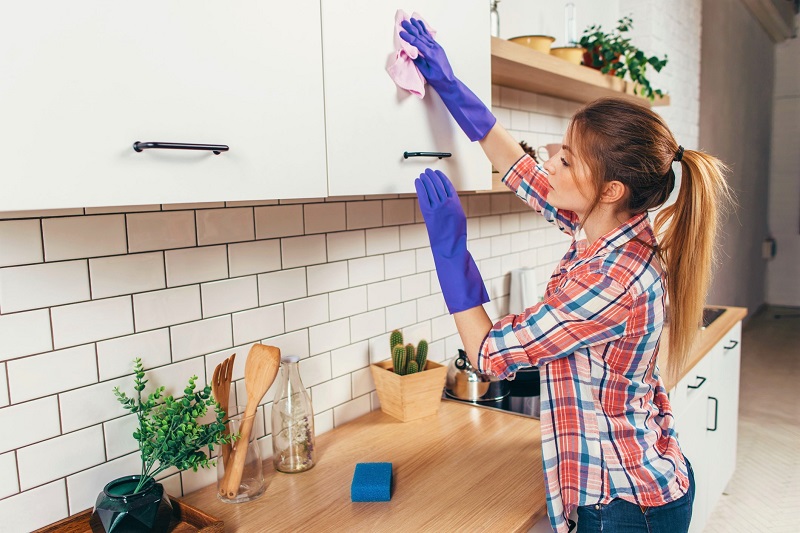 woman cleaning the furniture in the kitchen.
