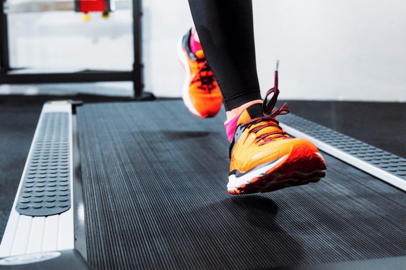person running with orange sneakers on treadmill