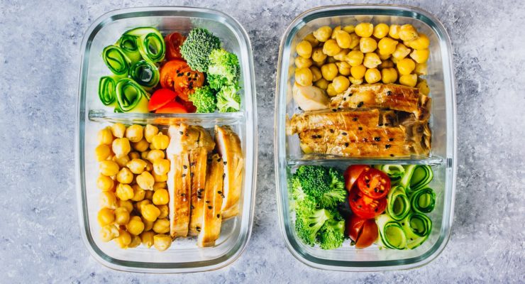 Healthy meal prep containers with chicken, chickpeas and fresh vegetables.